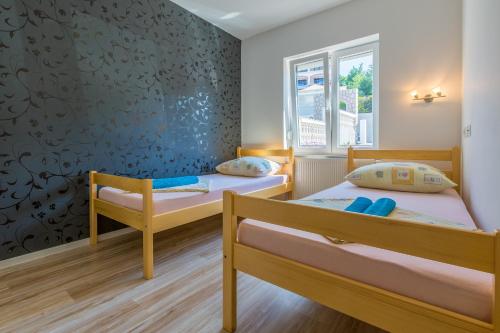 a room with two beds and a window at Apartmani Lucić in Crikvenica