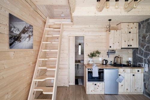 a kitchen with a staircase in a tiny house at Miętowa Górka in Ząb