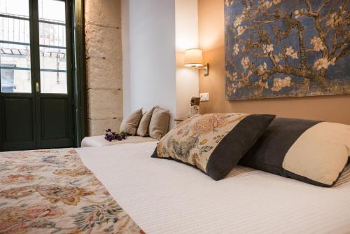 a bedroom with a bed and a painting on the wall at Luces de Catedral in Alicante