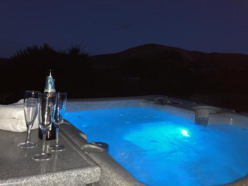 a swimming pool with wine glasses sitting next to a swimming pool at The Oaks in Church Stretton