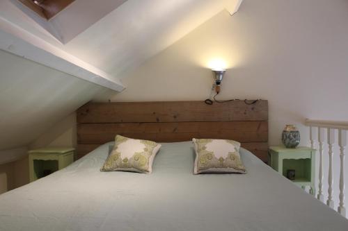 a bedroom with a white bed with two pillows at Het Huisje Breda in Breda
