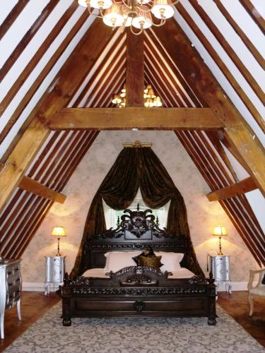 a bedroom with a canopy bed in a attic at Maenan Abbey Hotel in Llanrwst