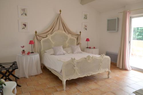 a bedroom with a large white bed with two tables at La Petite Aiguebonne in Allex