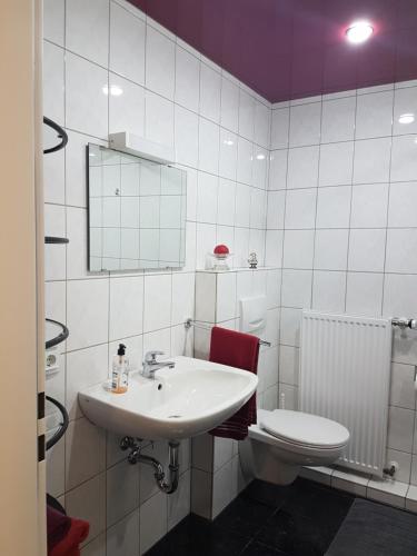 a white bathroom with a sink and a toilet at Business Apartment Lippstadt Nord 50 qm in Lippstadt