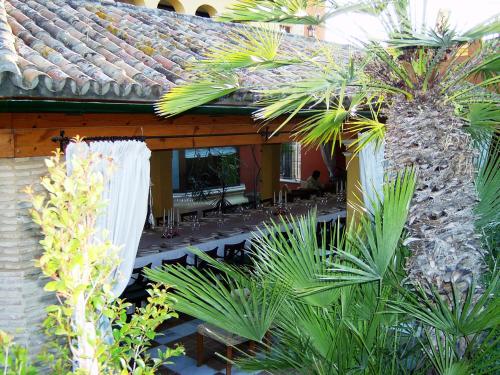 an outdoor patio with palm trees and a building at Hotel Soho Boutique Vistahermosa in El Puerto de Santa María
