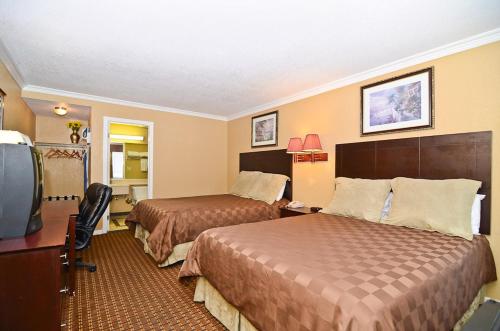 a hotel room with two beds and a television at Santa Clarita Motel in Santa Clarita