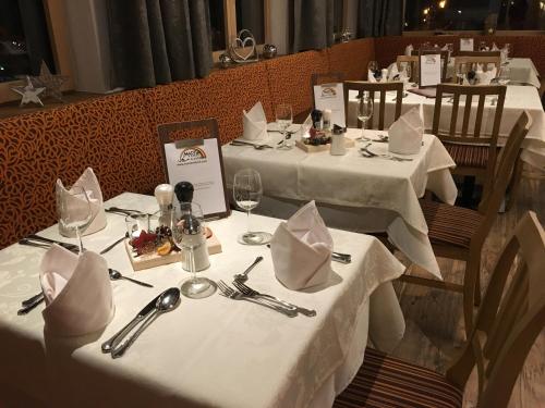 a group of tables with white table linens and napkins at Gasthof Martha in Nauders