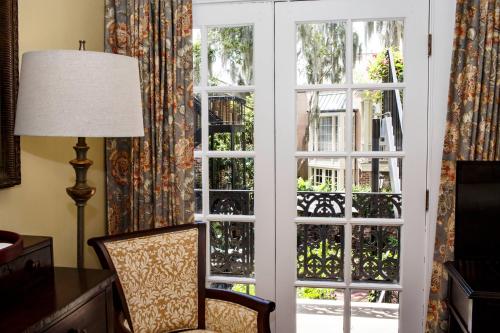 a room with an open door with a chair and a lamp at Eliza Thompson House, Historic Inns of Savannah Collection in Savannah