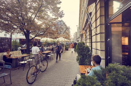 a group of people sitting at tables outside a restaurant at Between Us Bed and Breakfast in Warsaw