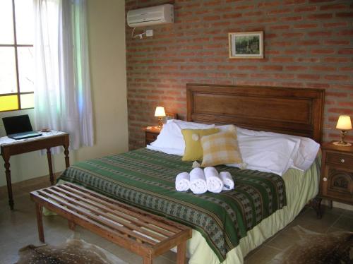 a bedroom with a bed with two towels on it at Posada Los Antiguos-Adults Only in Merlo