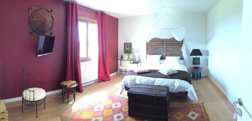 Schlafzimmer mit einem großen Bett mit roten Wänden in der Unterkunft Chambres Ambroisie in Gueytes-et-Labastide