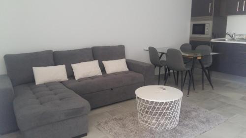 a living room with a couch and a table at Orange Studio in Vilamoura