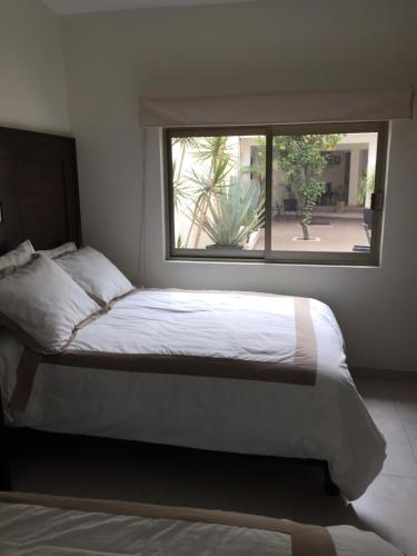 a bedroom with a large bed with a window at Hotel Yaocalli in San Martín de las Pirámides