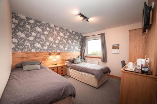 a bedroom with two beds and a window at Lathamor in Stornoway