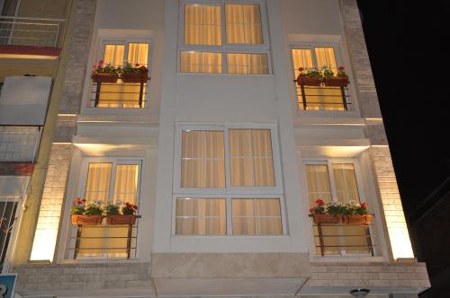 a white building with flowerpots on the windows at Deka Evleri in Izmir