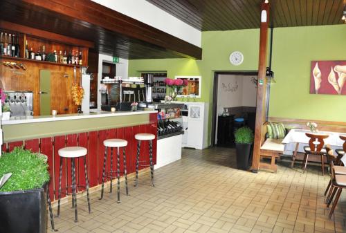 a restaurant with a counter and tables and chairs at Kirchenwirt Heinrich Gasthof in Deutschkreutz