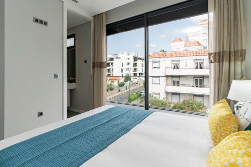 a bedroom with a bed and a large window at Funchal Lux I by An Island Apart in Funchal