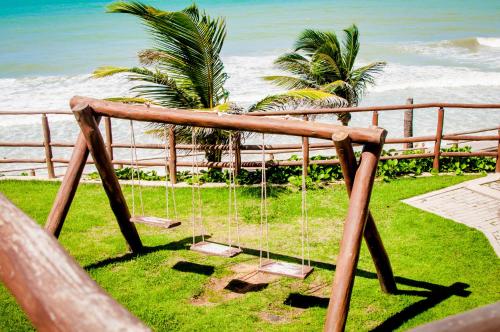 a swing in front of the beach with the ocean at Rifoles Praia Hotel e Resort in Natal