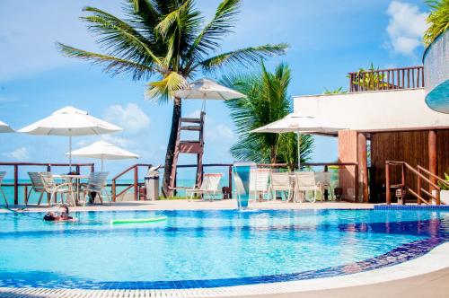 eine Person, die in einem Pool mit einer Palme schwimmt in der Unterkunft Rifoles Praia Hotel e Resort in Natal