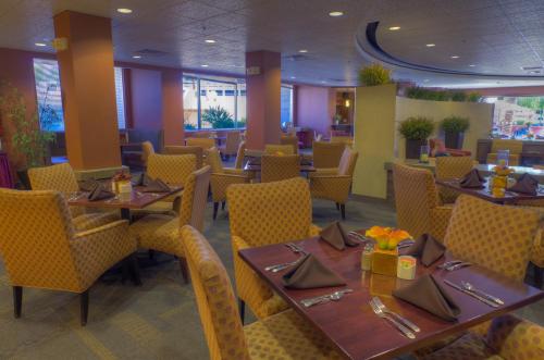a dining room table with chairs and tables at Ramada by Wyndham Phoenix Midtown in Phoenix