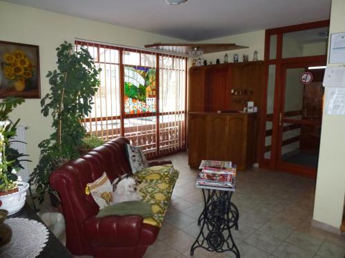 a living room with a couch and a table at Edelweiss Panzió in Pilisvörösvár