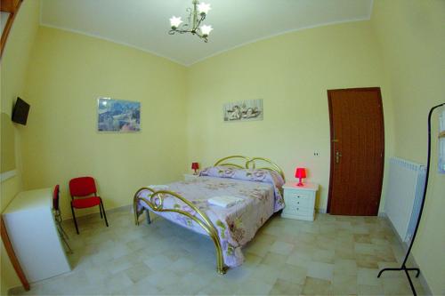 a bedroom with a bed and a red chair at La Collina di nonno Carmine in Santa Paolina