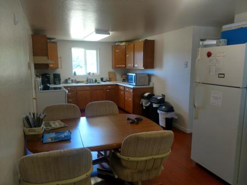 una cucina con tavolo, sedie e frigorifero di Lakeside Hostel & Guest House a Crescent City