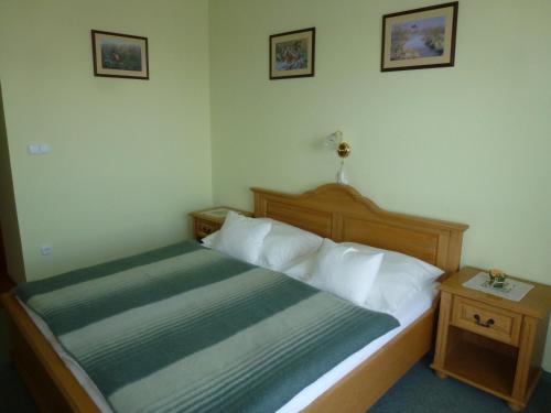 a bedroom with a bed with a green and white comforter at Edelweiss Panzió in Pilisvörösvár