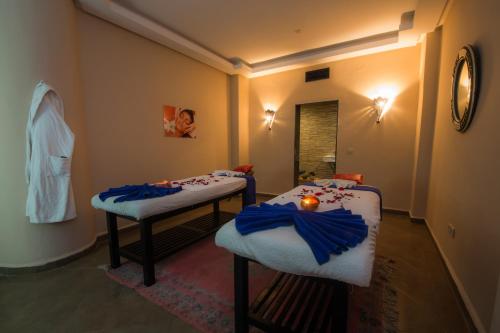 two twin beds in a room with blue bows at Zalagh Kasbah Hotel & Spa in Marrakech
