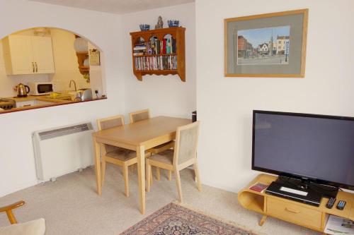 a kitchen and a dining room with a table and a television at 15 Oriel Drive. Glastonbury Town. View of the Tor. in Glastonbury