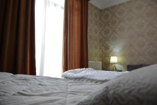 two beds in a hotel room with a window at North Kazbegi in Stepantsminda