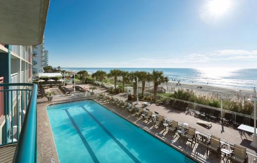 a view of a pool and the beach from a balcony at Paradise Resort in Myrtle Beach