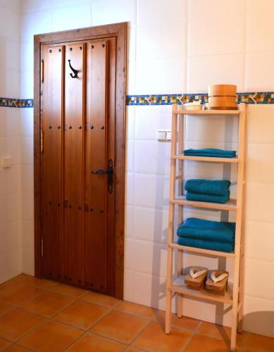 a bathroom with a wooden door and some towels at Competa Suites in Cómpeta