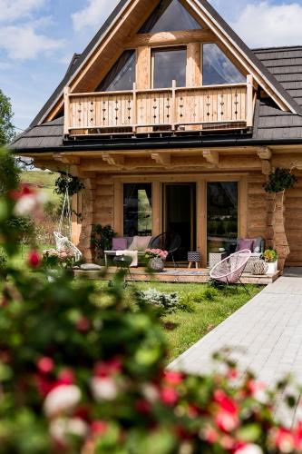 a log house with a balcony and a patio at Stylowa Chata in Zakopane