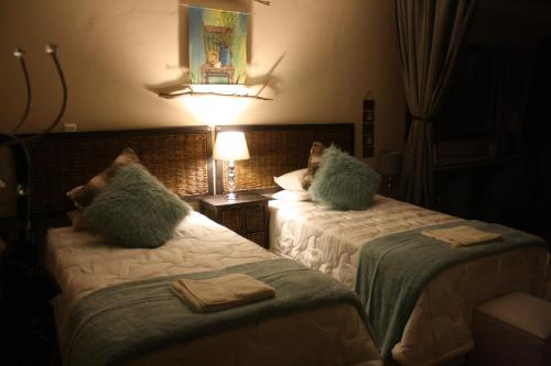 a hotel room with two beds with pillows on them at Suikerbosrant Sleep and go in Pretoria