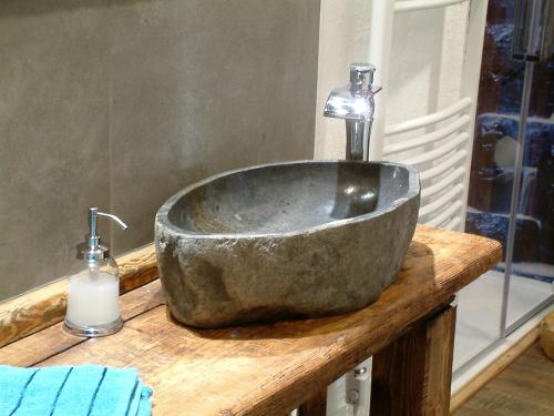 a bathroom with a stone sink and a bottle of soap at Ferienwohnung Woid Mandl in Velden am Wörthersee