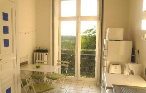 サン・ジェルヴェ・ラ・フォレにあるGîte de Charme 5 pers.のキッチン(テーブル、冷蔵庫付)、窓が備わります。