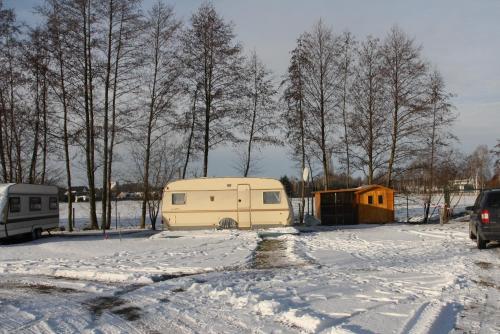 un camping-car garé sur un parking dans la neige dans l'établissement Erlebniscamping Lausitz - Campingplatz Ortrand / Camping Dresden, à Ortrand