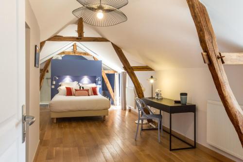 a bedroom with a bed and a desk at La Vie Voyage in Langeais