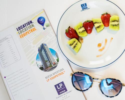 a plate of fruit and sunglasses next to a book at LP Equipetrol in Santa Cruz de la Sierra