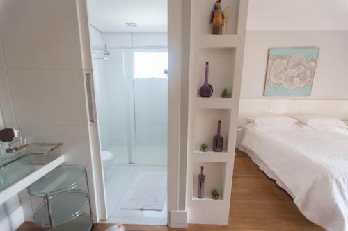 a bedroom with a bed and a glass shower at Suite casa de luxo in Campinas