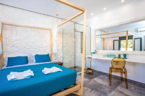 een slaapkamer met een blauw bed, een bureau en een spiegel bij Papenas Cozy Home in Faliraki