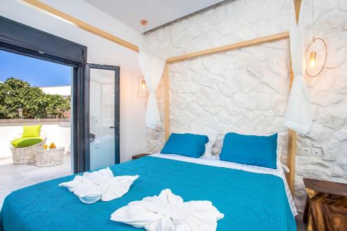een slaapkamer met een blauw bed en handdoeken bij Papenas Cozy Home in Faliraki