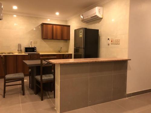 a kitchen with a counter top and a refrigerator at شقق فيلا للشقق المخدومه in Al Khobar