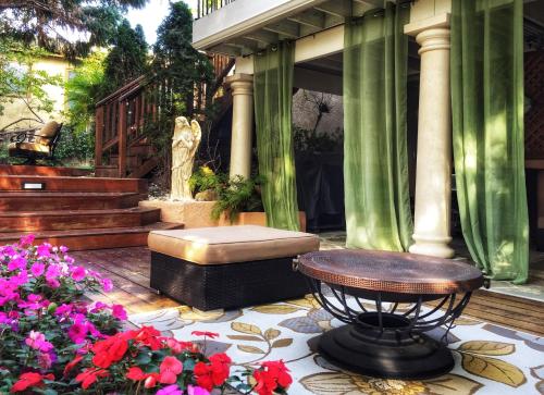 a patio with a bench and flowers and a statue at Little Paradise with Sauna Garden near Downtown in Saratoga