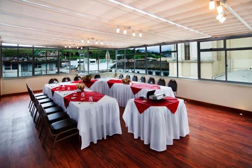 a group of tables with red and white tablecloths at Loft Hotel in Pasto