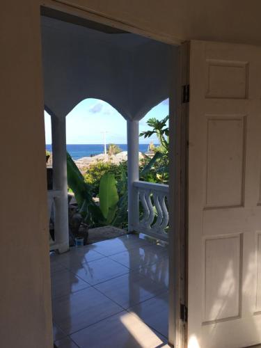 uma porta aberta para uma varanda com vista para o oceano em Quiet Escape Long Bay em Port Antonio
