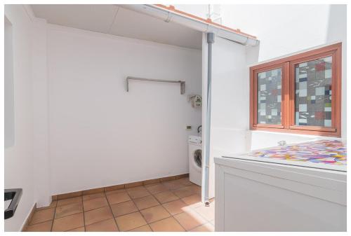 a laundry room with a washing machine and a window at La Casita del Centro in Vega de San Mateo