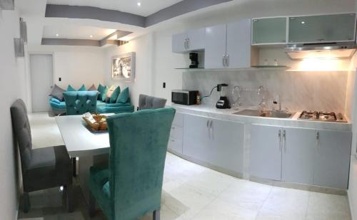 a kitchen with a table and chairs and a kitchen with a counter at Departamento Privado 3 recamaras in Mexico City