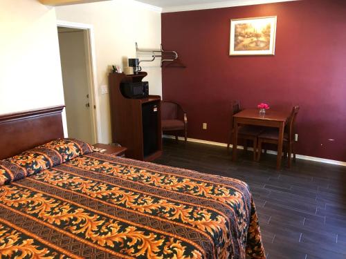 a hotel room with a bed and a table at Victory Motel Inn in Glendale